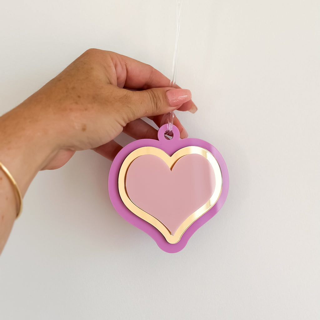 heart shaped pink and purple christmas decoration with personalised text engraved on the reverse